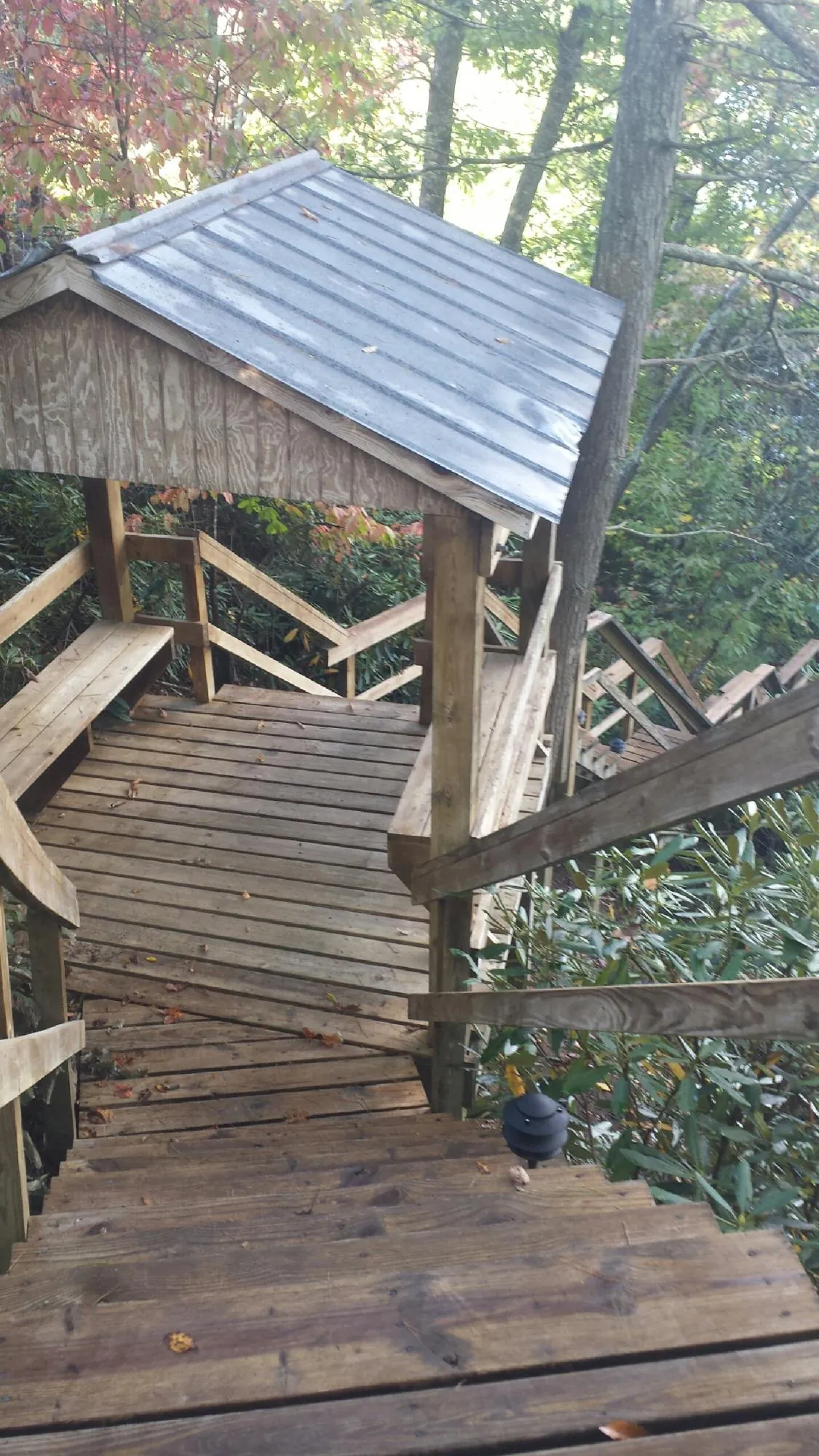 Metal roofed shelter over wooden steps on a wooded walkway — Skylight Repair & Installation work by our crew in Marshall