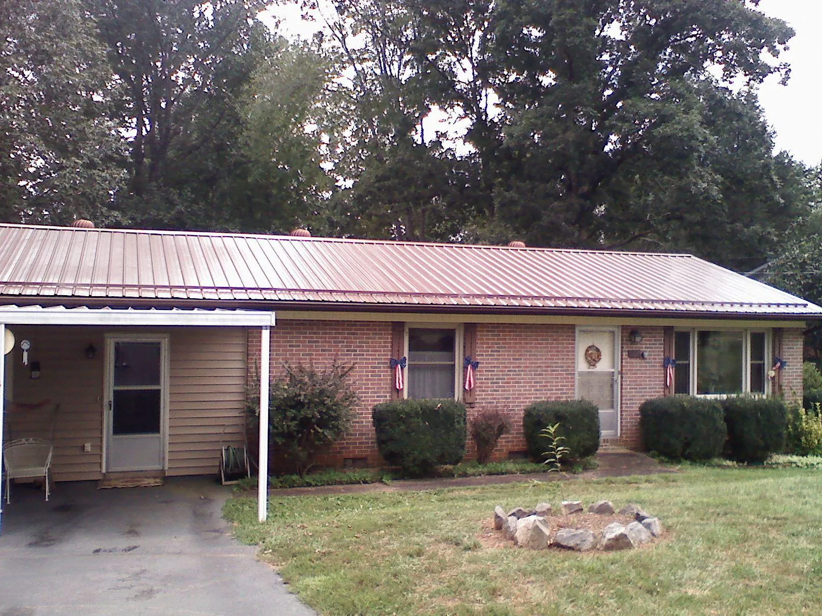 Bronze metal roof and carport on a brick ranch home — Roof Repair work by our crew in Marshall